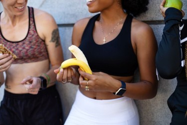 woman eating banana during workout break