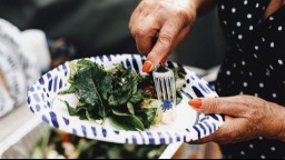 One older adult eating a salad rich in fiber on a paper plate