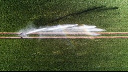 bird's eye view photo of sprinkler over green lawn