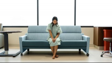 anxious young woman waiting alone in a hospital room for test results