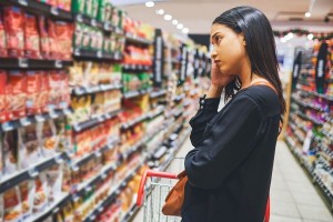 Woman shopping in a grocery store (Getty Images/Moyo Studio)