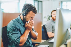 Sick sneezing office worker (Getty Images/Charday Penn)