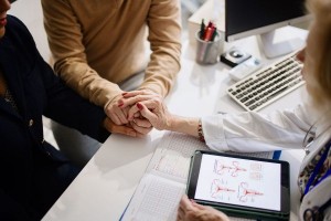 Doctor holding hands with her patients during a consultation (Getty Images/Anchiy)