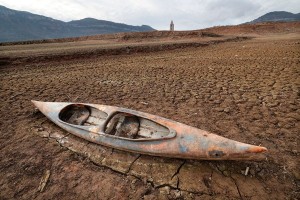 January 15, 2024: A kayak left on the dry soil next to the low water-level reservoir of Sau, with in background the Sant Roma de Sau church, in the province of Girona in Catalonia. (LLUIS GENE/AFP via Getty Images)