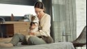 woman sitting on bed cuddling cat