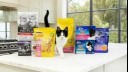 Black and white cat with Purina cat food packages