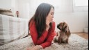 Woman and a pekingese sitting on the floor