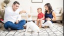 family and child playing with puppy