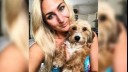 woman holding a long haired miniature dachshund