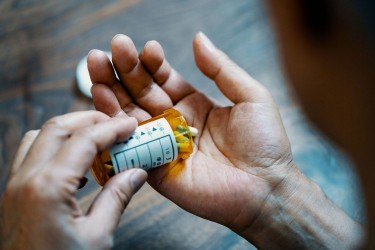 man holding pill bottle