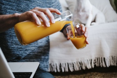 Man pouring a glass of orange juice