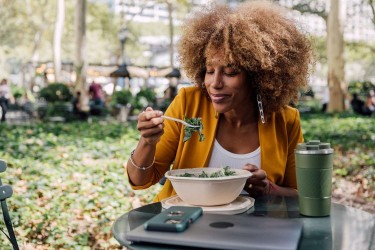 Woman eating a salad in the park