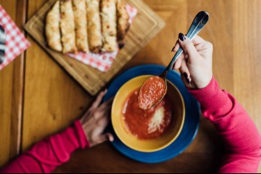 woman eating tomato soup