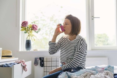 woman using asthma inhaler