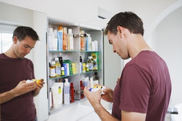 Man looking in medicine cabinet