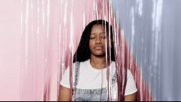 portrait of black woman with long hair holding her eyes closed