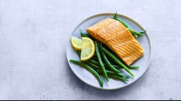 A plate of salmon, green beans, and lemon