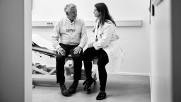 An older man talks with a female doctor