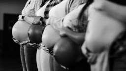 Five pregnant women hold their bellies