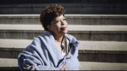 photo of older black woman in blue shawl gazing into the distance