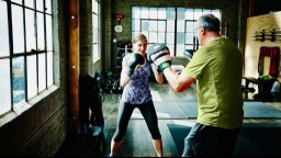 A woman and a man boxing at a gym