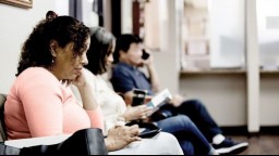 Three people sit in a doctor's waiting room