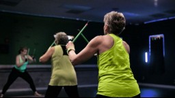 older person wearing neon green tank top exercising at the gym