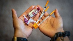 hands holding insulin vials and syringes