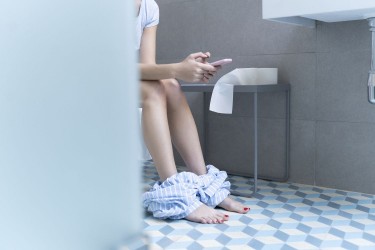 Girl sitting on toilet