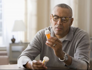 Man looking at prescription bottles