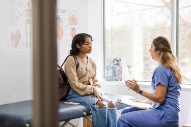 Young woman talking to doctor