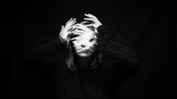 Blurred black and white image of female with hands over face