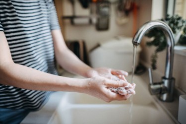 woman washing hands in sink