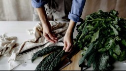 close-up of person's hands as they prepare kale