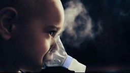 A young girl uses an asthma inhaler