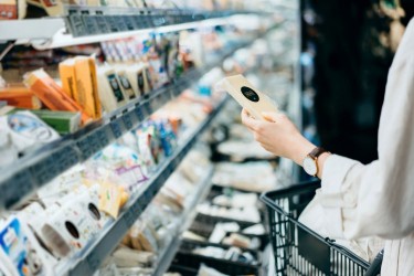 woman shopping in cheese aisle at supermarket